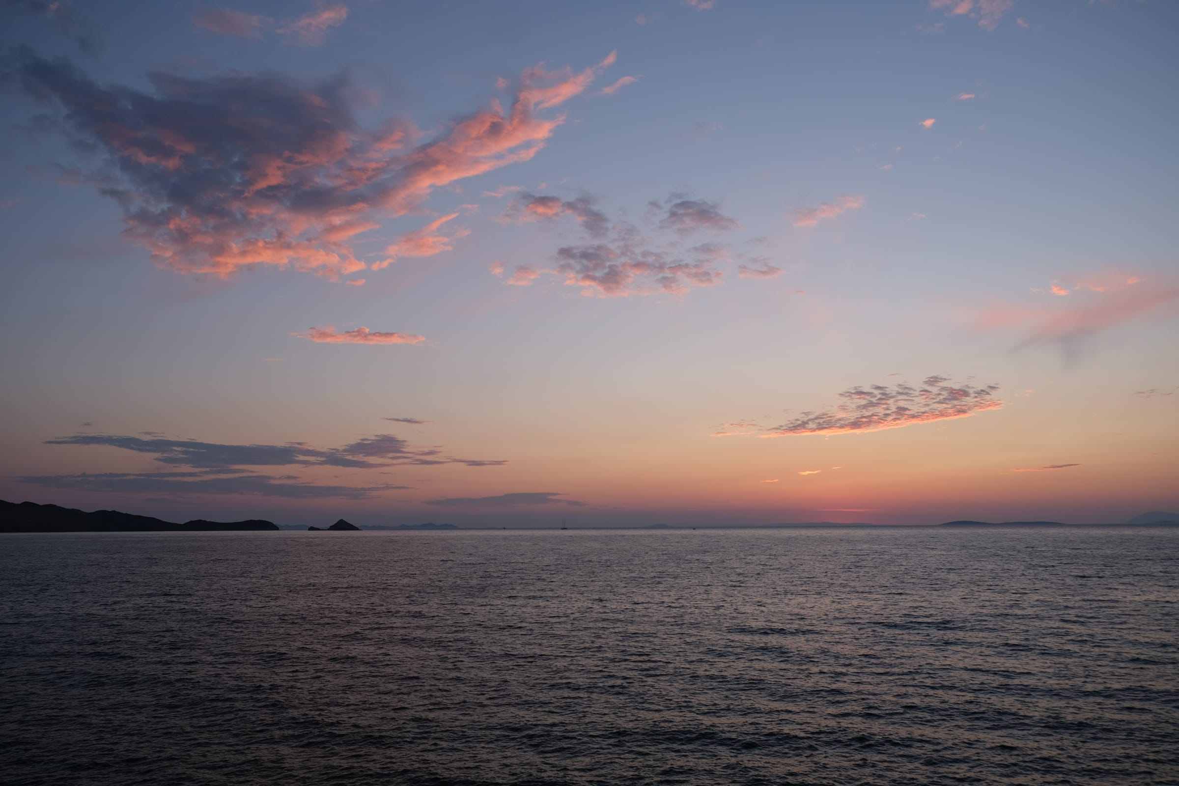 Calm sea under a cloudy sky at sunset
