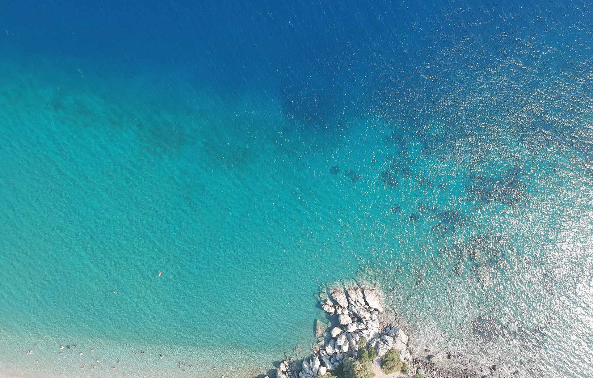 Aerial view of a cove with turquoise water and a rocky shore