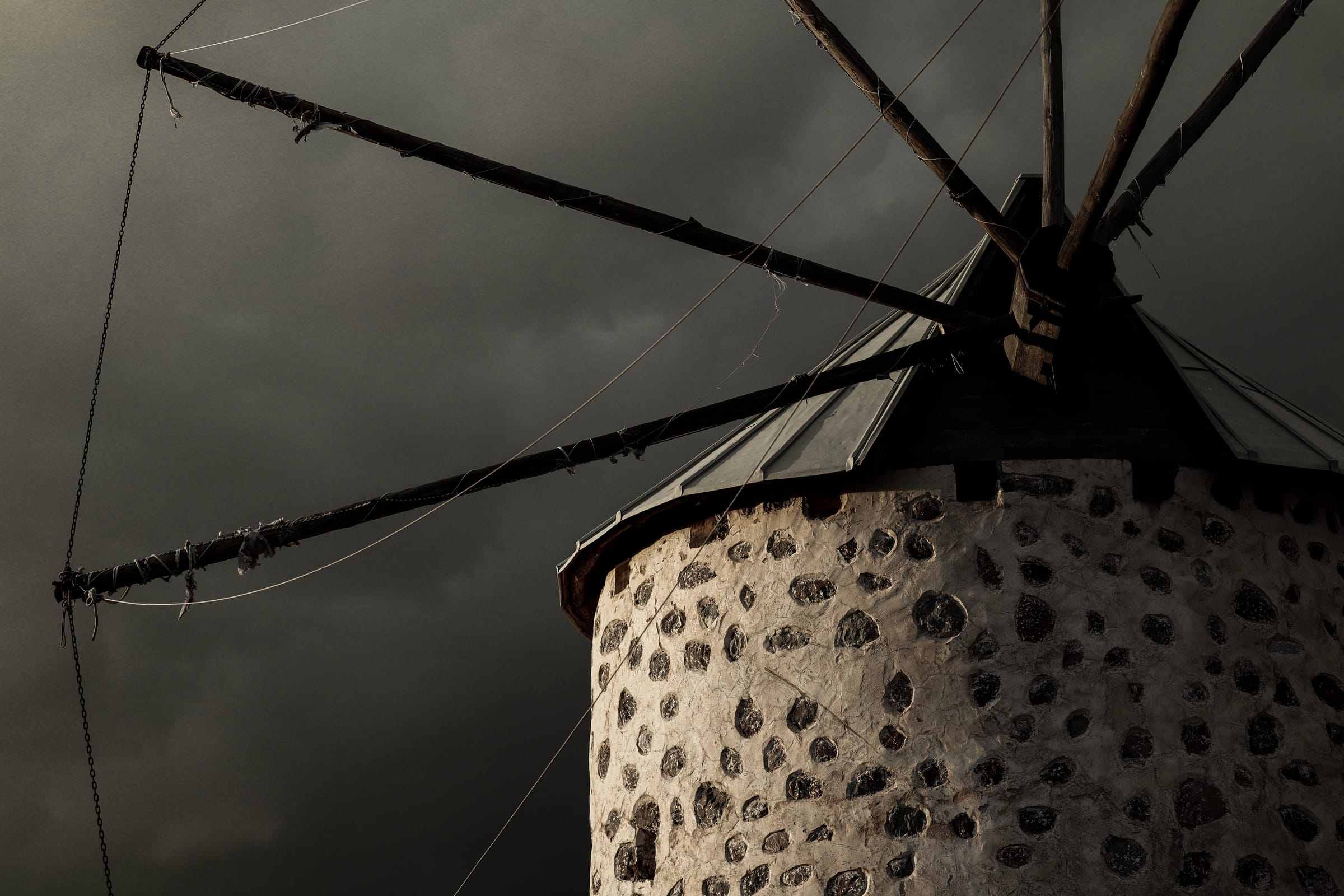 A stone windmill under a dark, cloudy sky